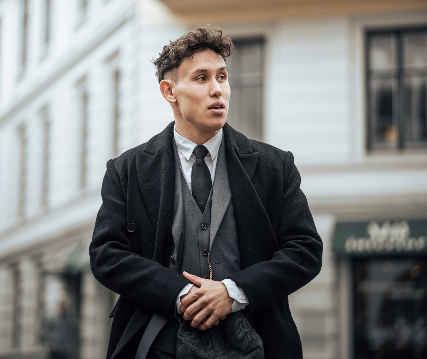 Elias Omberg i frakk og dress i bygata