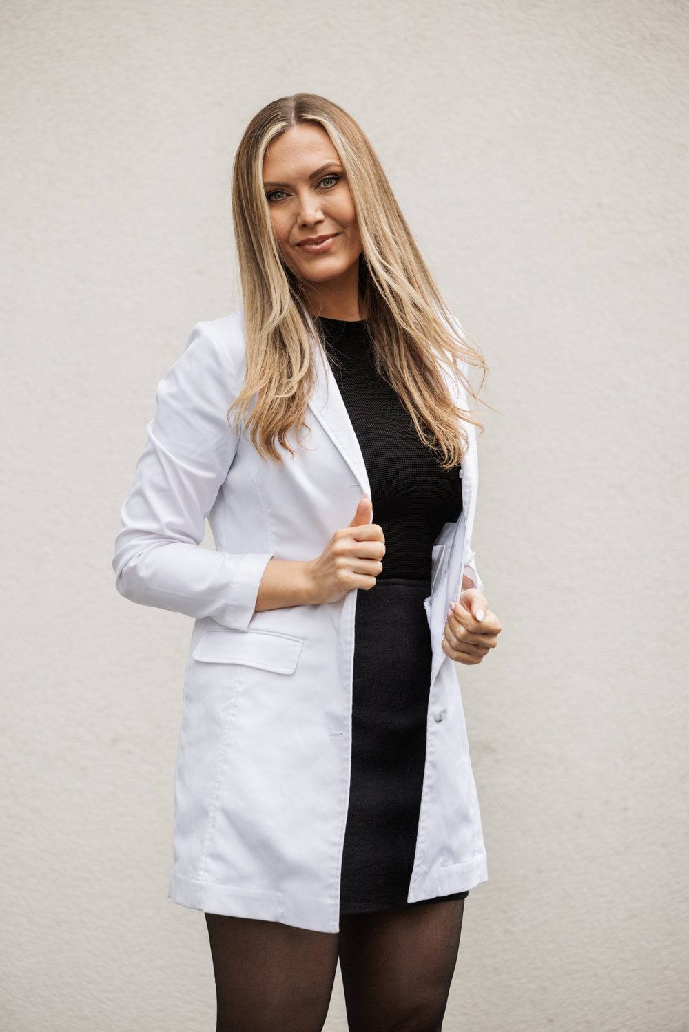 Helene Winther in a white lab coat holding her lapel