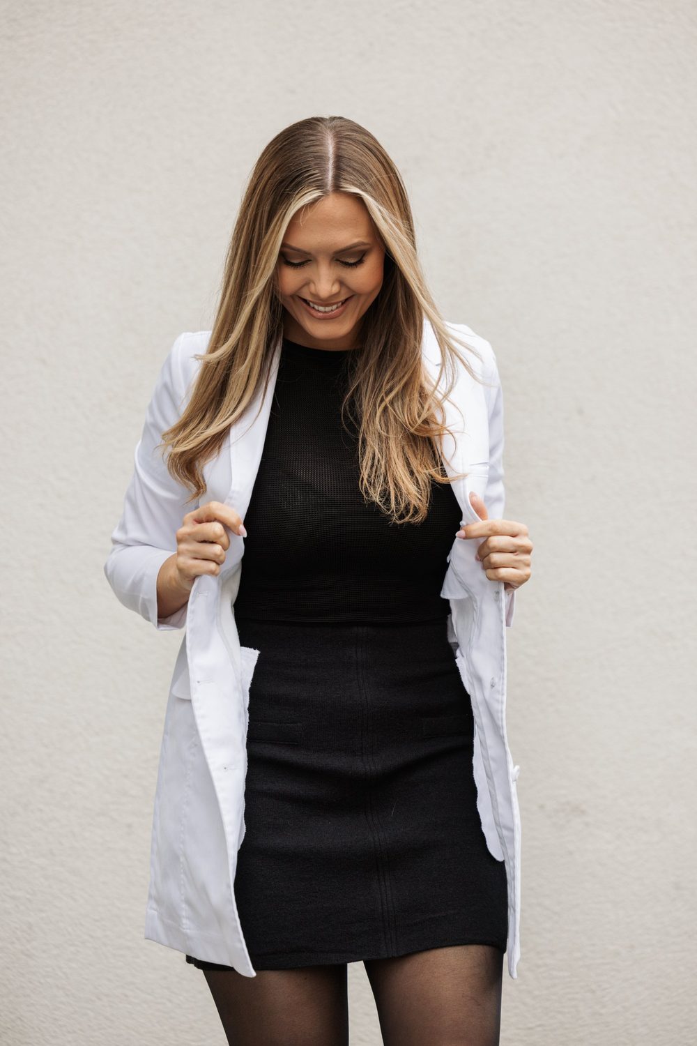 Helene Winther in a white lab coat laughing and looking down